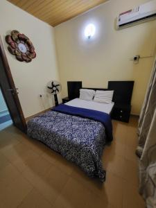 - une chambre avec un lit et une horloge murale dans l'établissement Entire 3 Bedroom Bungalow - Home away from home, à Lagos