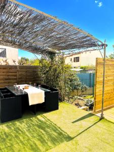a backyard with a table and a pergola at Villa Mars YourHostHelper in Narbonne