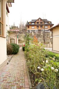 a brick walkway in front of a house with flowers at Петрос Family Hotel in Yaremche