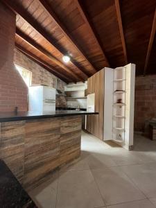 a large kitchen with a counter and a refrigerator at La Palma Hotel Fazenda in Indaiatuba