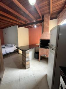 eine Küche mit einem Tisch und einem Kühlschrank im Zimmer in der Unterkunft La Palma Hotel Fazenda in Indaiatuba