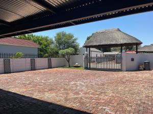 a brick driveway with a gate and a fence at La Belle Guesthouse Parys in Parys