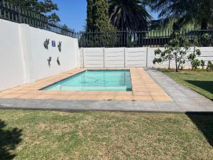 a small swimming pool in a yard next to a fence at La Belle Guesthouse Parys in Parys