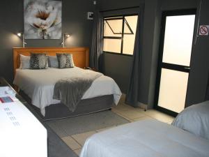 a bedroom with two beds and a window at La Belle Guesthouse Parys in Parys