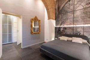 1 dormitorio con cama y espejo en la pared en terisuite 14, en Siena