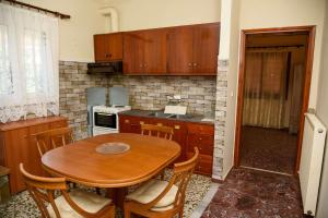 a kitchen with a wooden table and a table and chairs at Michael Apartment Tyros in Tyros