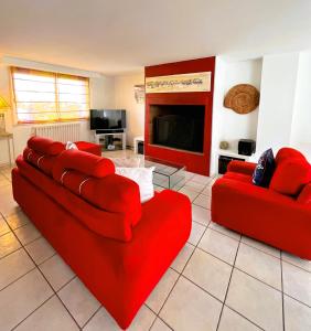 a living room with two red couches and a fireplace at Villa Mars YourHostHelper in Narbonne