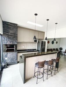 uma cozinha com um balcão com bancos em Beach House Olímpia - Casa Temporada em Olímpia