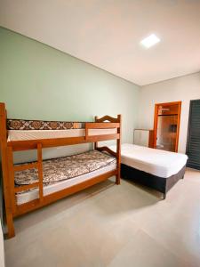 um quarto com 2 beliches em Beach House Olímpia - Casa Temporada em Olímpia