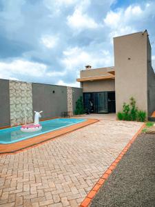 uma casa com piscina na frente de uma casa em Beach House Olímpia - Casa Temporada em Olímpia