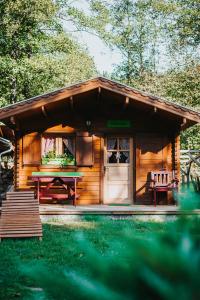 a wooden cabin with a picnic table and a bench at Vidra Park in Sicasău