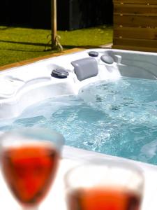 a jacuzzi tub filled with water with two glasses at Villa Mars YourHostHelper in Narbonne