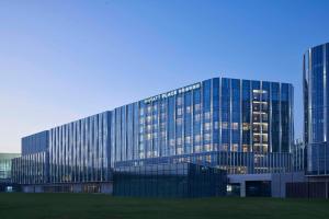 a large glass building with a lot of windows at Hyatt Place Hangzhou International Airport in Hangzhou