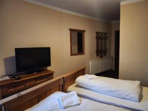 シュチルクにあるMamma Mia - pokoje gościnneのベッド2台、薄型テレビが備わるホテルルームです。