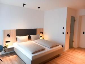 ein Schlafzimmer mit einem großen weißen Bett in einem Zimmer in der Unterkunft HOLI City Apart Hotel Berlin in Berlin