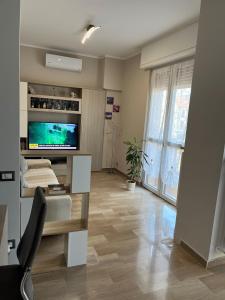a living room with a television and a table with a chair at CINI Infinity HOUSE in Cinisello Balsamo