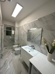 La salle de bains est pourvue d'un lavabo, de toilettes et d'un miroir. dans l'établissement Bicocca Modern Apartment, à Milan