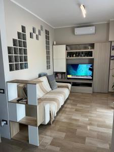 sala de estar con sofá y TV de pantalla plana en CINI Infinity HOUSE, en Cinisello Balsamo