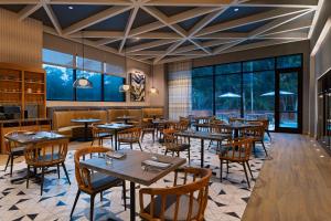 a restaurant with tables and chairs and windows at Hyatt Regency Conroe in Conroe