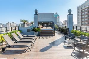 a rooftop deck with chairs and tables on a building at Loft em frente a Redenção 805 in Porto Alegre