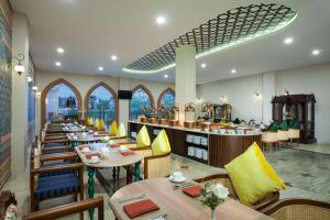 un ristorante con tavoli e sedie e un bar di Alhambra Hotel & Convention, BW Signature Collection a Tasikmalaya