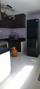 a kitchen with a black refrigerator and a stove at Bloomfields Residences in Balintiouac