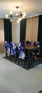 a dining room with blue chairs and a wooden table at Bloomfields Residences in Balintiouac