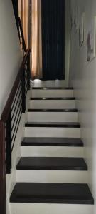 un escalier avec des marches blanches et noires et une fenêtre dans l'établissement Bloomfields Residences, à Balintiouac