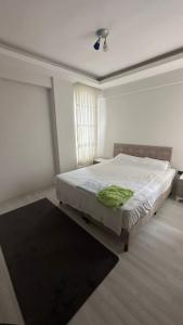 Un dormitorio con una cama con una manta verde. en BVK, en Muğla