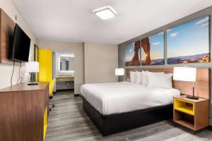 a hotel room with a bed and a flat screen tv at Days inn by Wyndham Albuquerque Northeast in Albuquerque