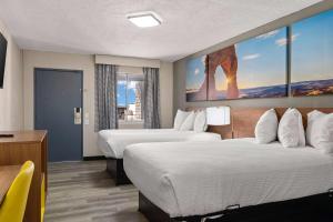 a hotel room with two beds and a desk at Days inn by Wyndham Albuquerque Northeast in Albuquerque +5 photos