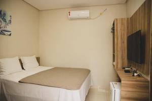 a small bedroom with a bed and a tv at HOTEL POUSADA DAS ROSAS in Carolina +12 photos