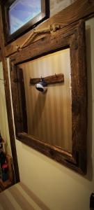 a mirror with a wooden cross on a wall at Uki & Sofi mountain house in Kopaonik