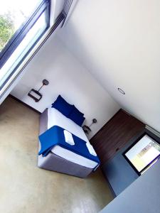 Un dormitorio con una cama con almohadas azules y una ventana en Hermosa Villa con piscina, en Los Santos