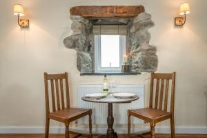 a table and two chairs in a room with a window at Stabal-Byrdir in Dyffryn +17 photos
