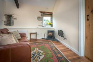 a living room with a couch and a fireplace at Stabal-Byrdir in Dyffryn