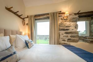 a bedroom with a large bed and a stone wall at Stabal-Byrdir in Dyffryn