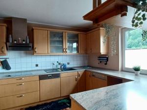 eine Küche mit Holzschränken und einem großen Fenster in der Unterkunft Ferienwohnung am Hügel in Schmallenberg