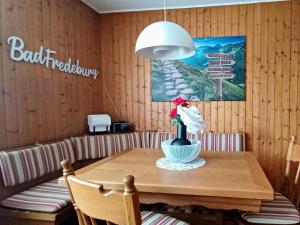 einen Esstisch mit einer Blumenvase darauf in der Unterkunft Ferienwohnung am Hügel in Schmallenberg