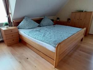 een bed met blauwe lakens en kussens in een kamer bij Ferienwohnung am Hügel in Schmallenberg