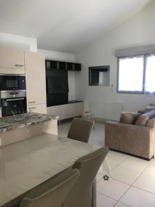 kuchnia i salon ze stołem i kanapą w obiekcie Ski 3 Vallées à 80m télécabine de l'Olympe - appt 50m2, 3étoiles w mieście Brides-les-Bains