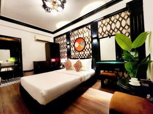 um quarto com uma cama, uma mesa e uma cadeira em ROSA ZEN Hotel Spa em Ho Chi Minh