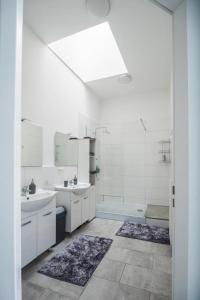 a white bathroom with two sinks and a tub at Gemütliche Ferienhaushälfte im Herzen Mainz in Mainz