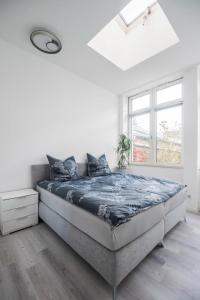 een slaapkamer met een groot bed in een witte kamer bij Gemütliche Ferienhaushälfte im Herzen Mainz in Mainz