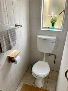 baño blanco con aseo y ventana en Budler Stay, 3 Bedroom, Self Catering apartment en Upington