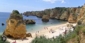 un groupe de personnes sur une plage près de l'eau dans l'établissement Anchor House, à Albufeira