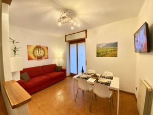 a living room with a red couch and a table at Casa alla Fontana in Serravalle allʼAdige