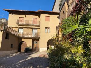 un gran edificio con un balcón en el lateral. en Casa alla Fontana, en Serravalle allʼAdige