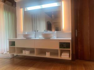 a bathroom with two sinks and a large mirror at The Gatehouse in Saint James +12 photos