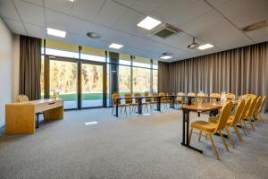 une salle de conférence avec des tables, des chaises et des fenêtres dans l'établissement Hotel Bonifacio SPA&SPORT Resort, à Sochocin